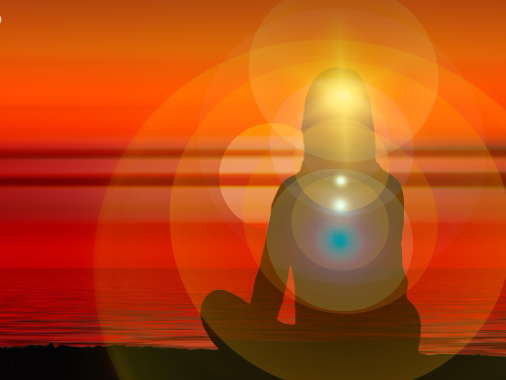 Mulher sentada frente ao mar, meditando tranquila em contato com seu inconsciente.
